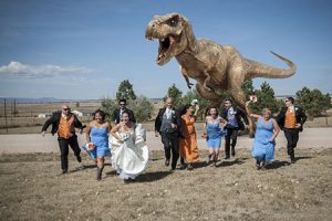 bridal party running across a field, in fear, from tyrannosaurus out in Colorado