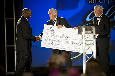 Ameriplan corporation handing out over sized checks to employees at corporate gala