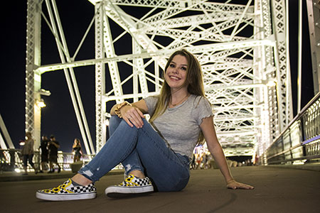 Young woman sitting on Pedestrain bridge in downtown Nashville, TN