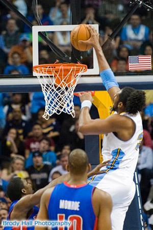 Denver Nugget player slam dunking the ball at a NBA game