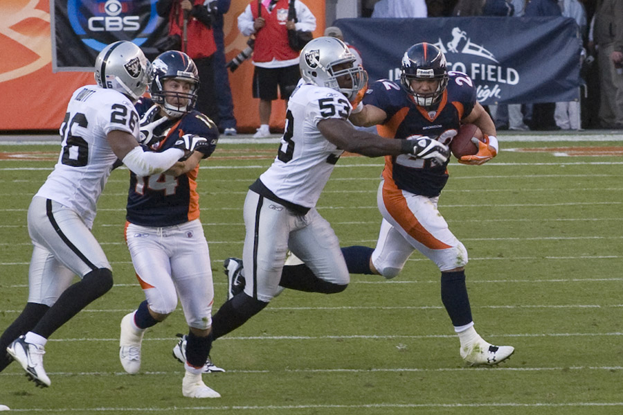 Denver Bronco running back pushing through the Raider's defense.