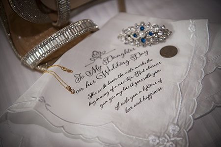 Bride shoes and brooch, on top of a personalized hand kerchief