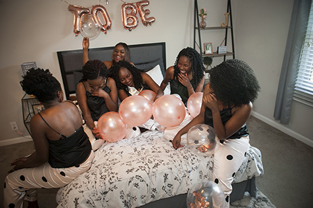 Rachel's bachelorette party in PJs and playing on the bed with balloons
