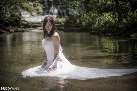 Bride kneeling in water at Rutledge Falls, TN