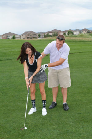 Playboy playmate getting lessons at the Playboy golf tournament