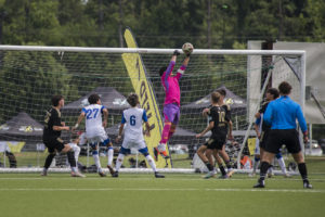 Goalie leaping to bump the ball over the goal!