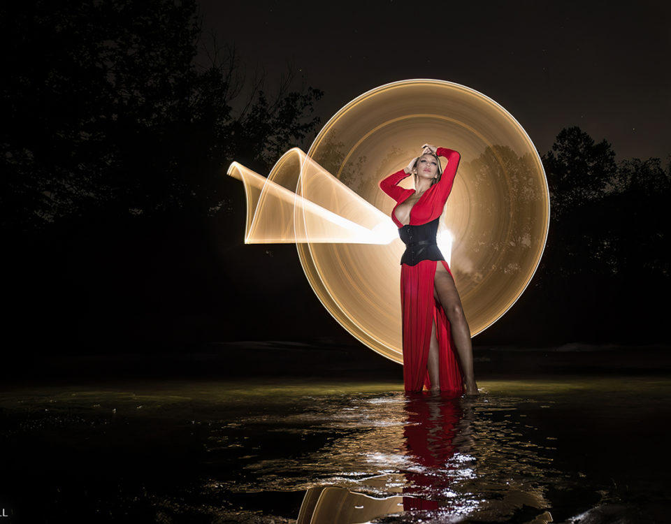 Harlow Wilde in Red dress and black corset in a light painting shot.