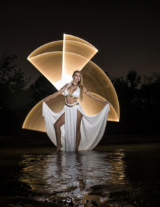 Harlow wilde doing light painting with a candle design behind her