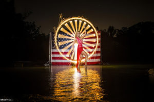 Kristy Kay posing for a light Panting photo with the American flag behind her.