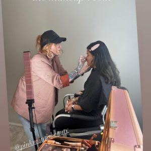 Stephanie Wilson, pink Mantis Beauty applying make-up