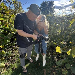 Photo of brody talking to a client and showing images on the back of the camera