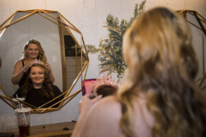 Hair stylist placing a tiara on the head of a bride to be!