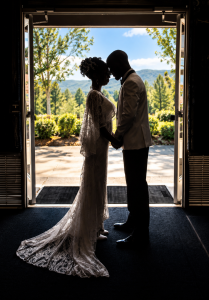 Bride and groom silhouetted in a church doorway, standing forehead to forehead after their Colorado wedding.
